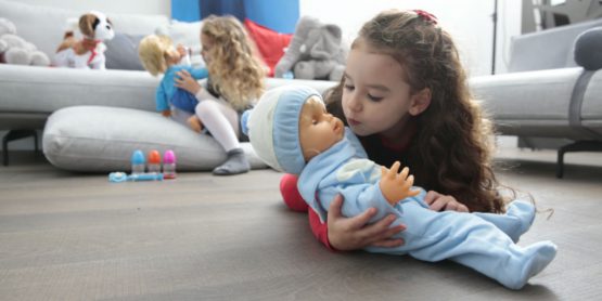 Bambine giocano in salotto con Cicciobello e i suoi accessori