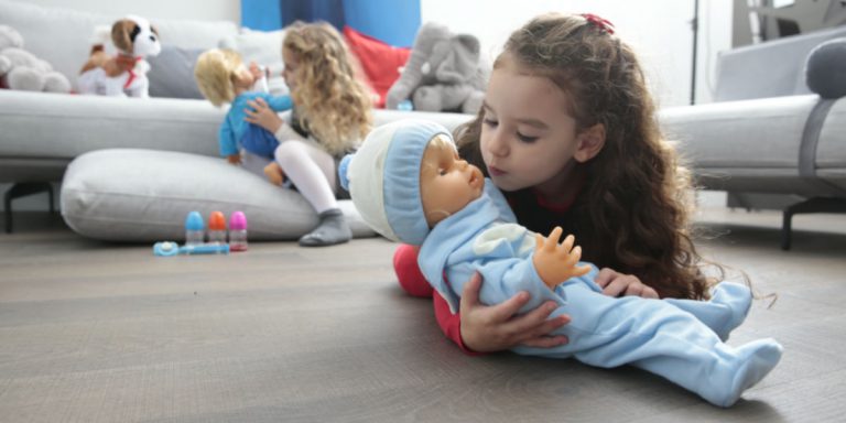 Bambine giocano in salotto con Cicciobello e i suoi accessori