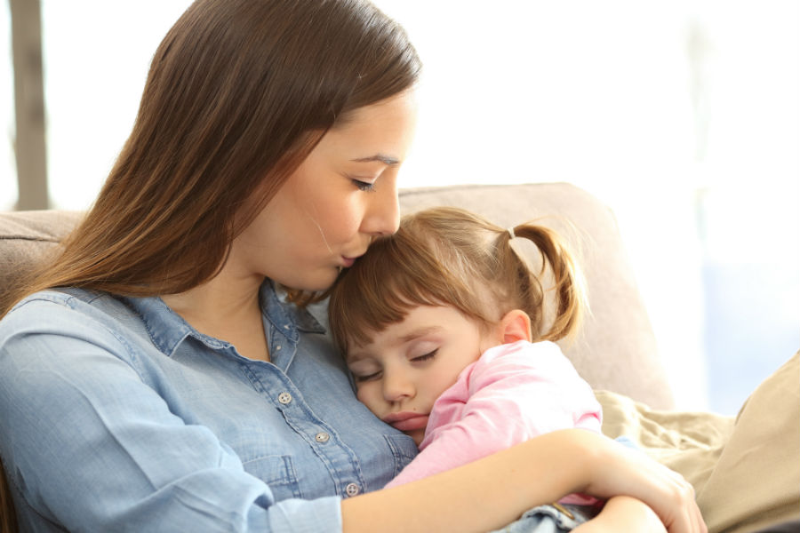 Mamma coccola la sua bambina sul divano