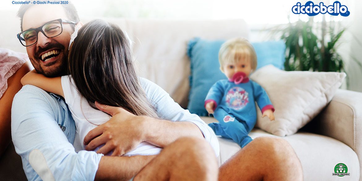 un papà abbraccia la figlia, sullo sfondo Cicciobello Mille Baci