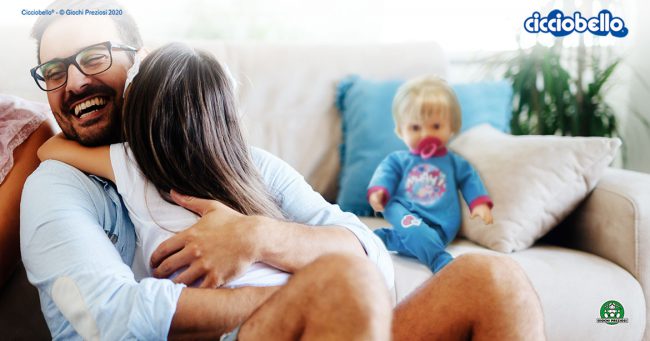 un papà abbraccia la figlia, sullo sfondo Cicciobello Mille Baci