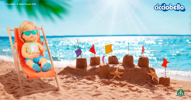 Cicciobello Sunny su una spiaggia con castello di sabbia